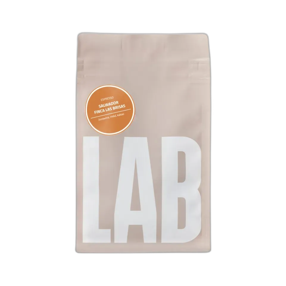 Opakowanie kawy Coffeelab Salvador Finca Las Brisas Carlos Pola w eleganckim, beżowym kolorze z dużym, białym napisem "LAB". Na opakowaniu znajduje się pomarańczowa etykieta z informacją o profilu smakowym kawy: żurawina, miód, kakao. Kawa dedykowana do espresso, pochodzi z Salwadoru z plantacji Finca Las Brisas. Produkt zapakowany w hermetyczne opakowanie z zamknięciem strunowym, które zapewnia świeżość ziaren.