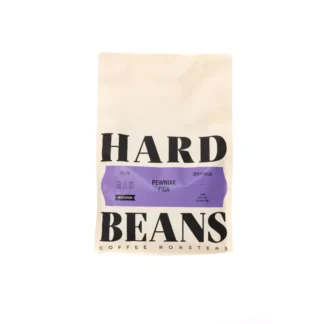 Na zdjęciu widoczna jest paczka kawy Hard Beans Pewniak Figa, opakowana w elegancki, minimalistyczny papier. Produkt ten to kawa jednoźródłowa, idealna do parzenia w metodzie filtrowej, charakteryzująca się wyjątkowym smakiem i aromatem.