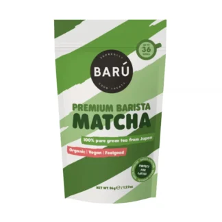 Opakowanie Premium Barista Matcha przedstawia 100% czystą zieloną herbatę z Japonii, idealną do przygotowywania latte. Produkt jest organiczny, wegański i przez producenta zalecany dla miłośników zdrowego stylu życia.